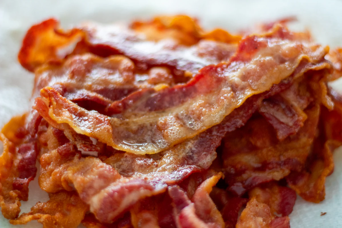 Crispy cooked bacon strips resting on a plate