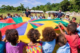 Children are playing with a colorful parachute together.