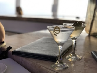 Two martinis sit on a table, ready to be enjoyed.