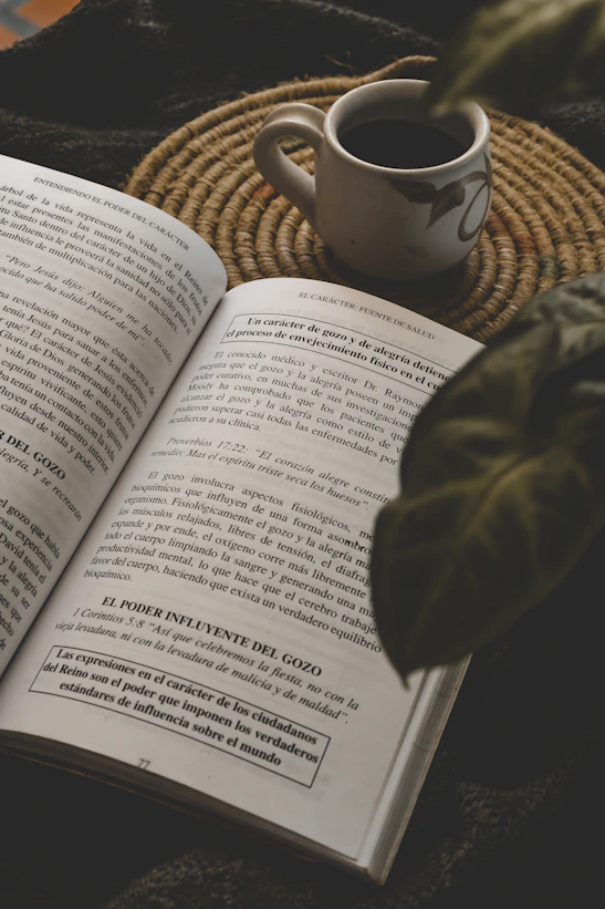Book, coffee, and plant make a cozy reading scene.