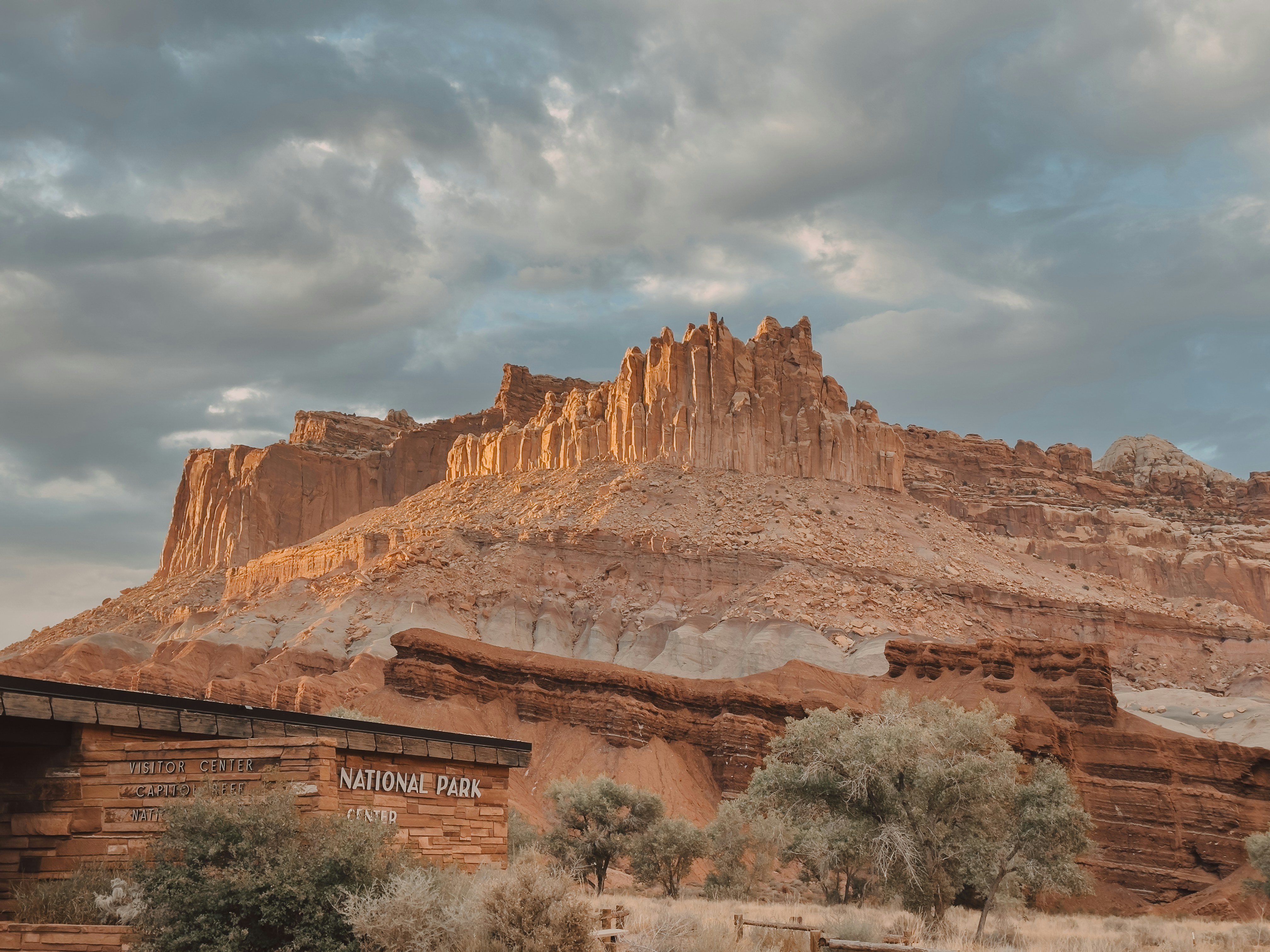 Dramatic sunset illuminates a desert mountain landscape.