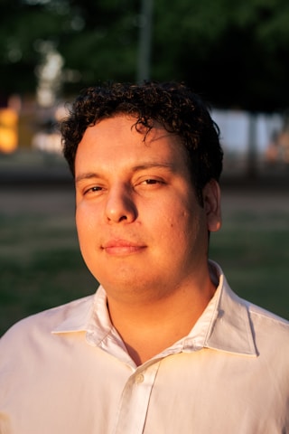 A man with curly hair smiles at the camera.