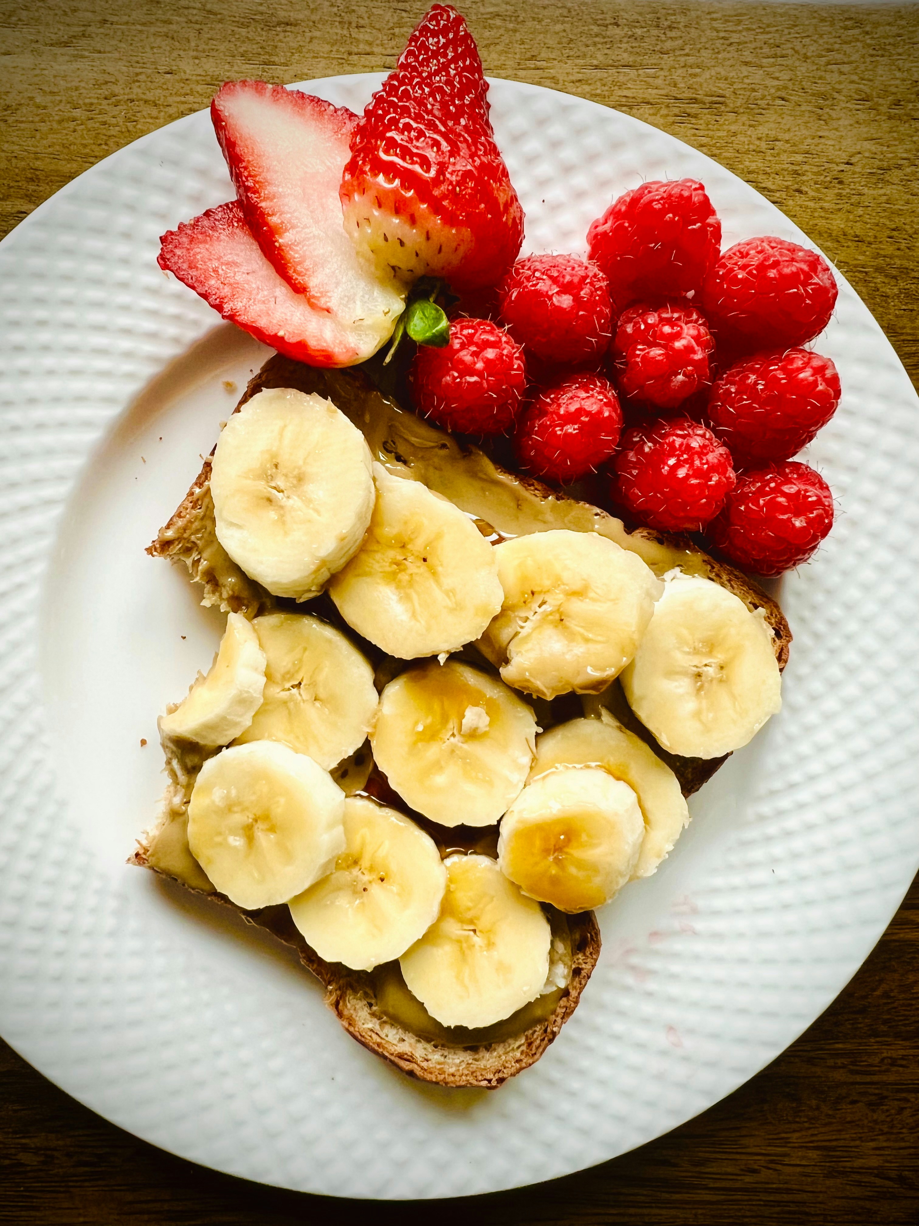 Toast with fruit on a white plate.
