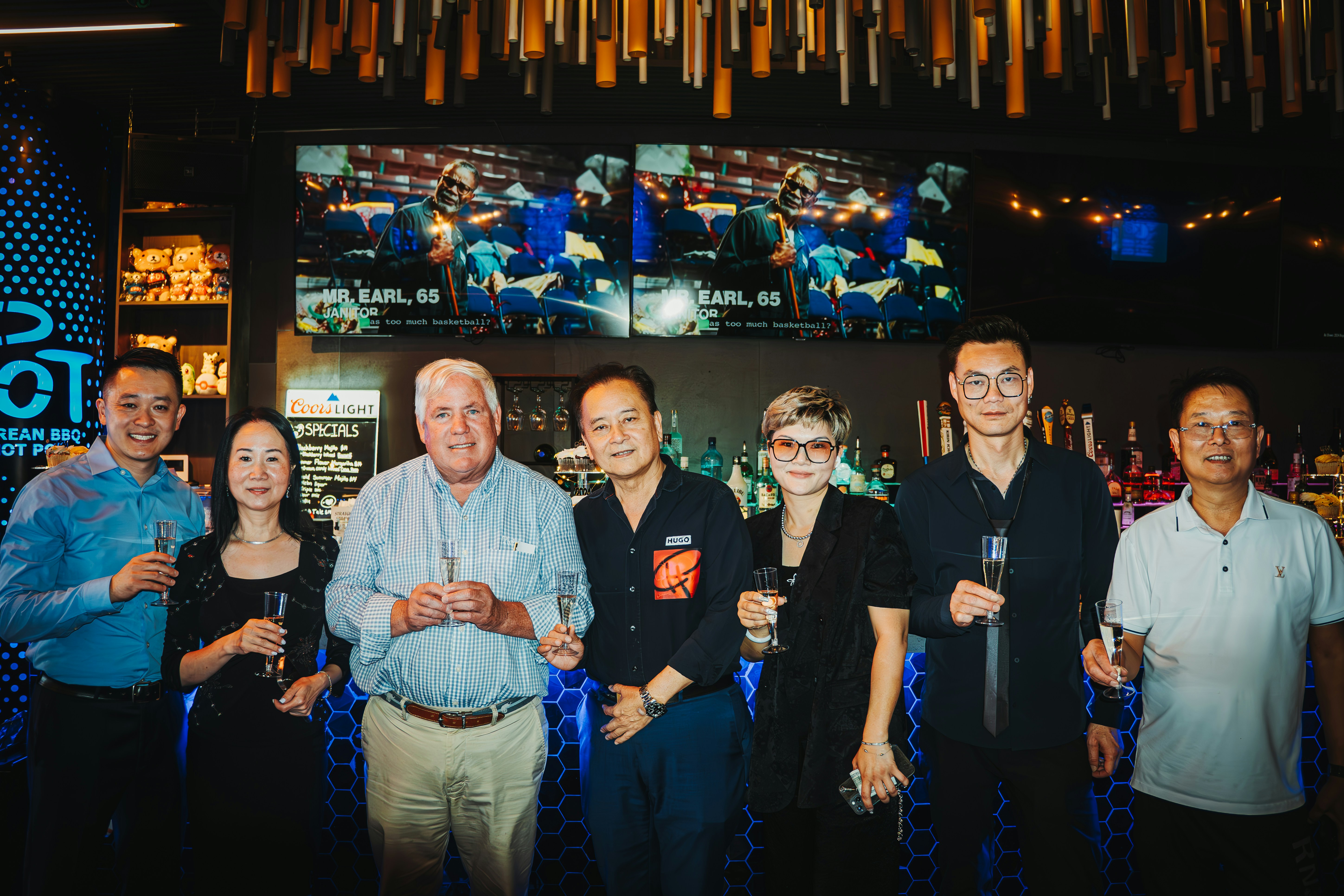 Group of men and women posing together at a darts bar venue`