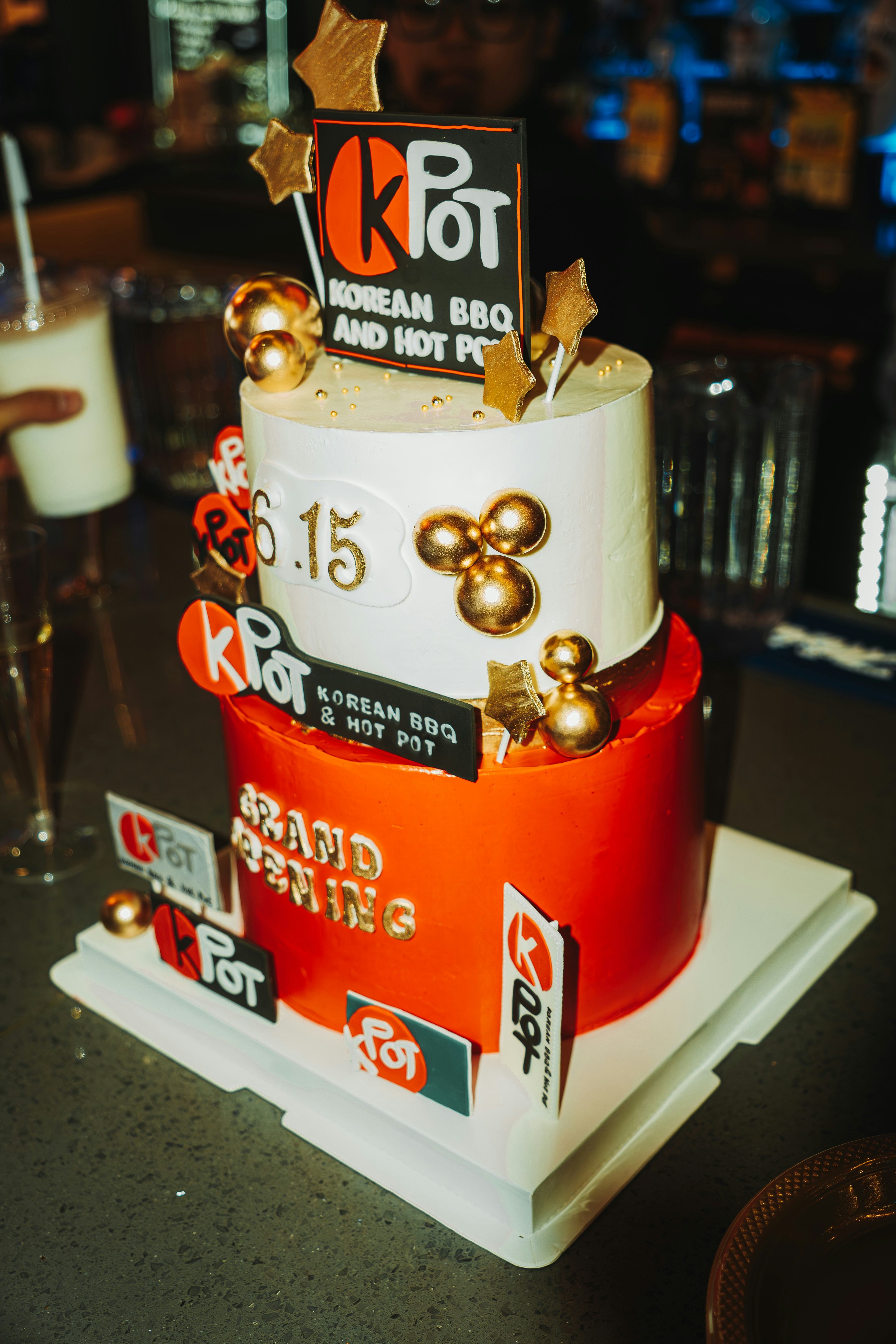 A two-tiered cake celebrates kpot's grand opening.