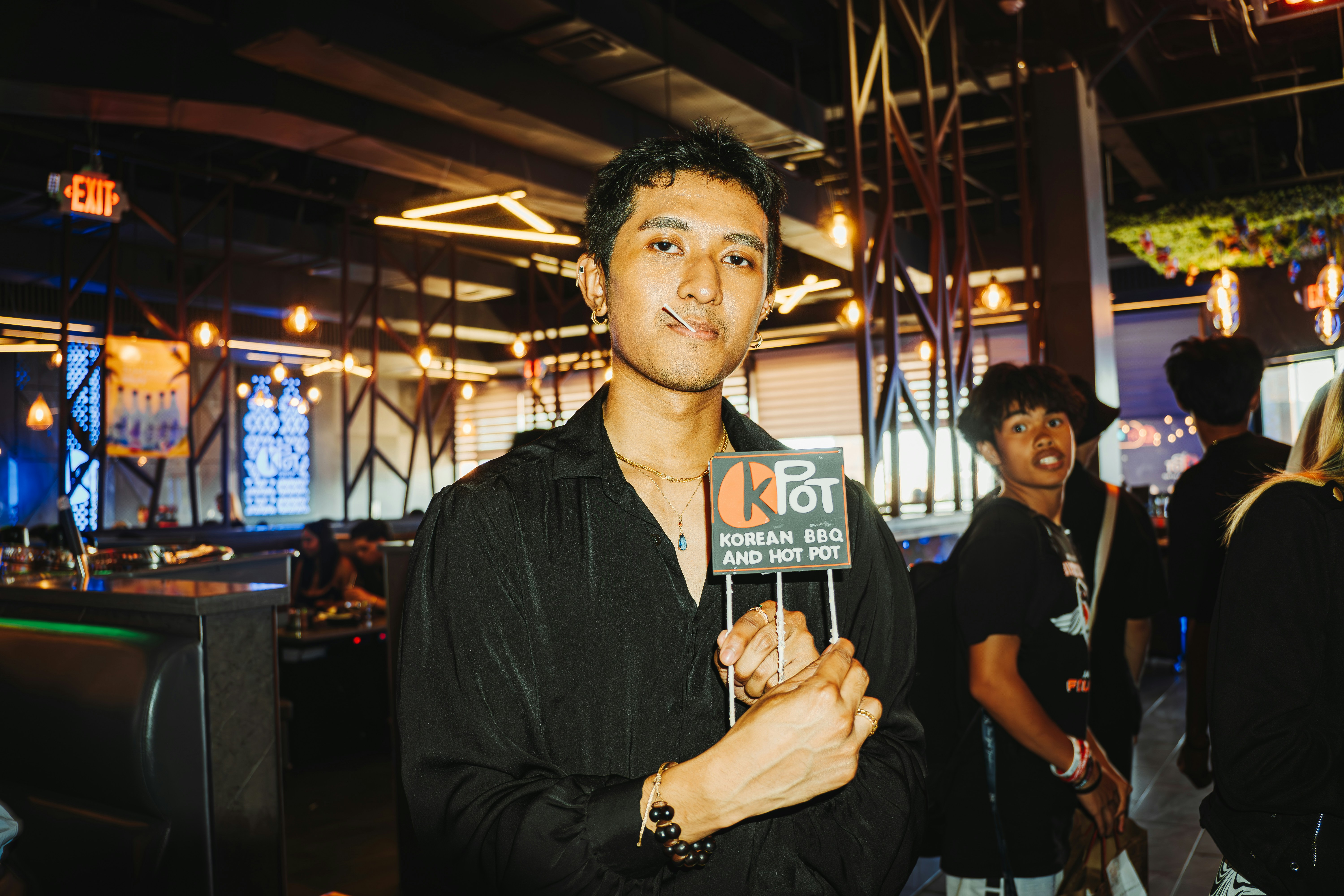 Man holds a sign in a restaurant.