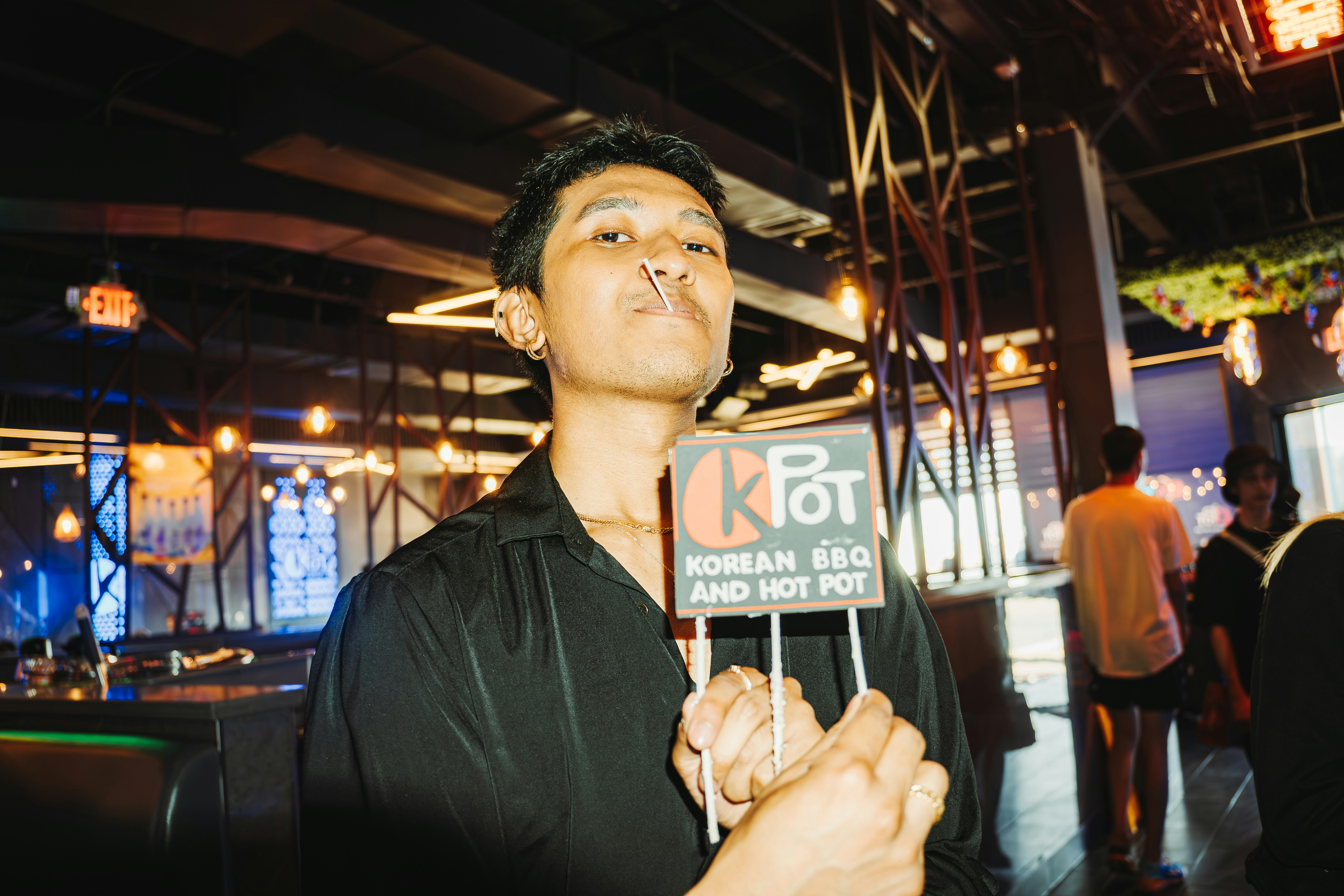 Seorang pria berpose dengan tanda restoran.