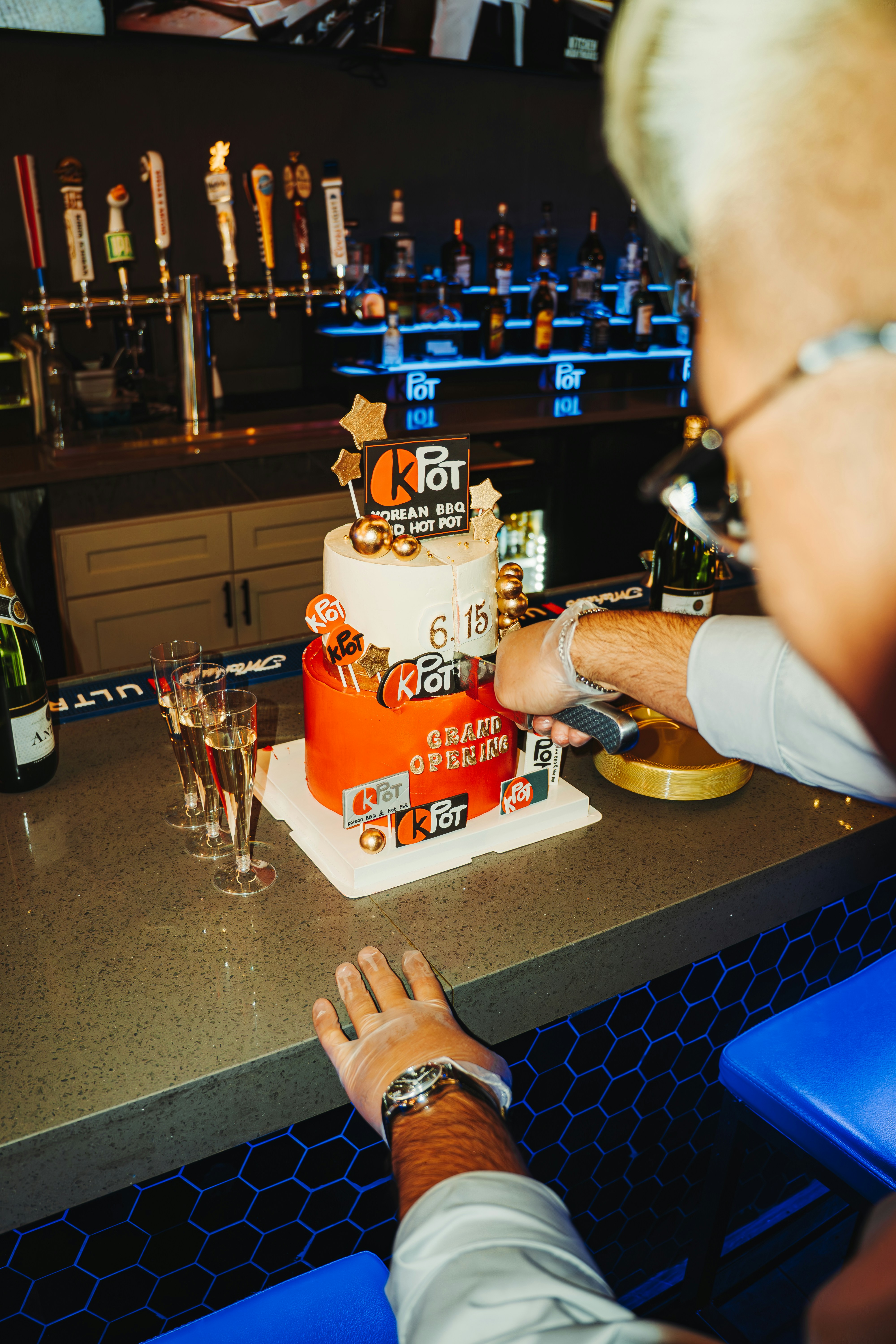 Someone is cutting a birthday cake at a bar.