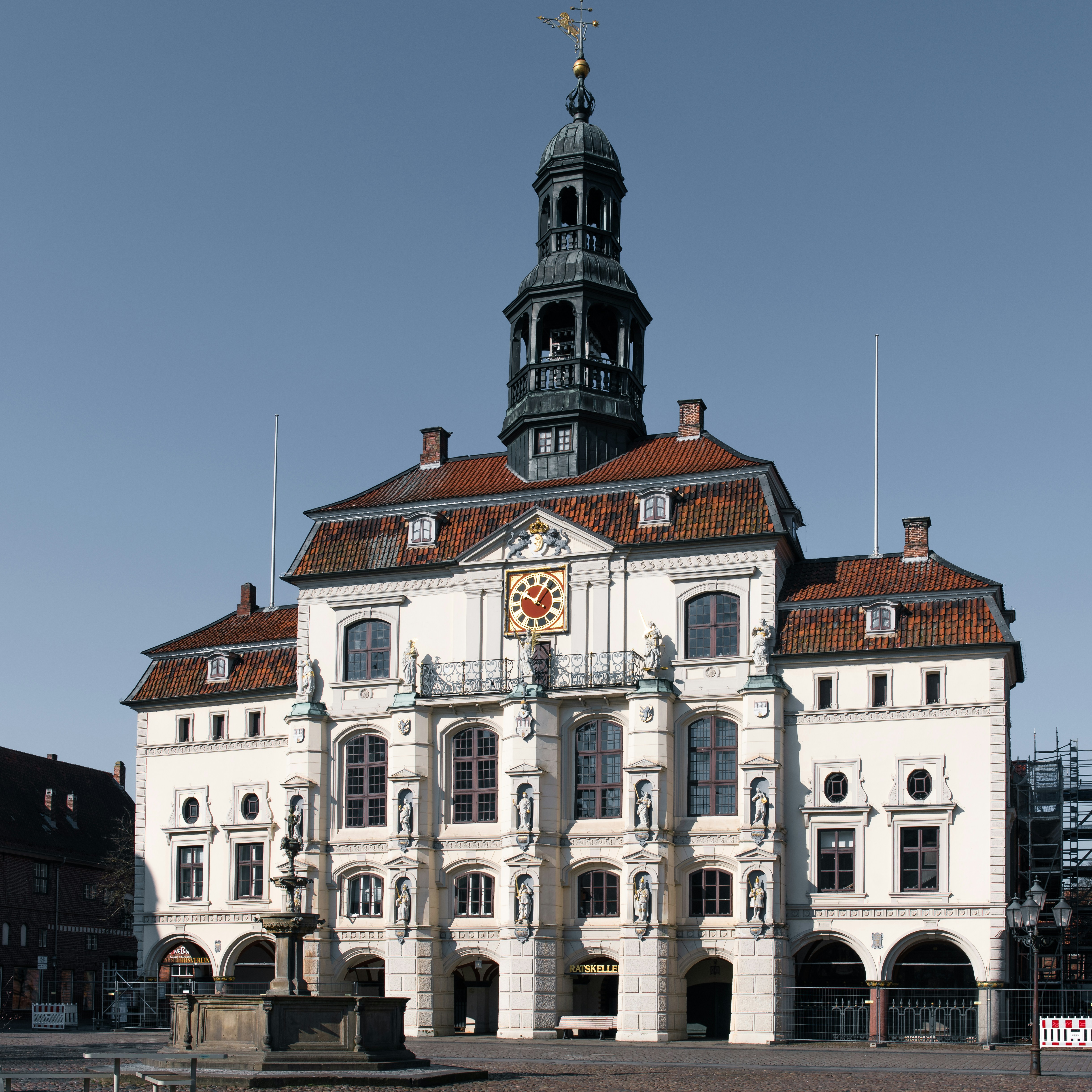 A stately white building has a tall steeple.