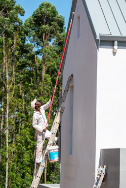 A painter is working on a building's exterior