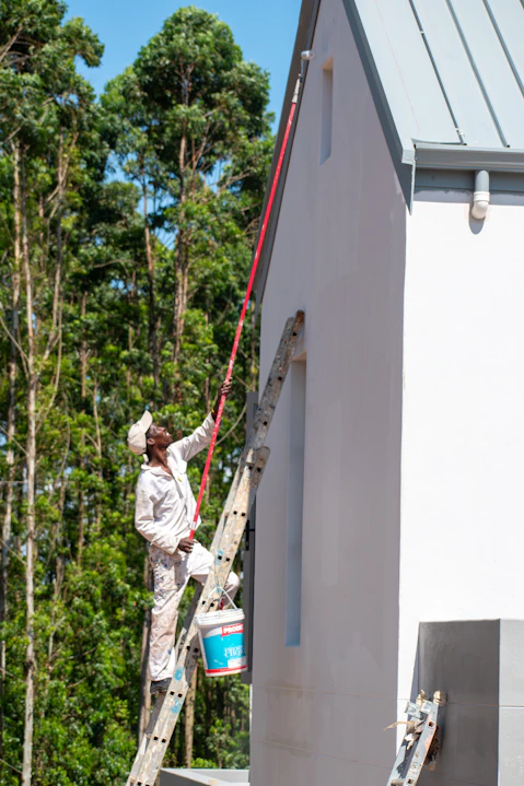 A painter is working on a building's exterior