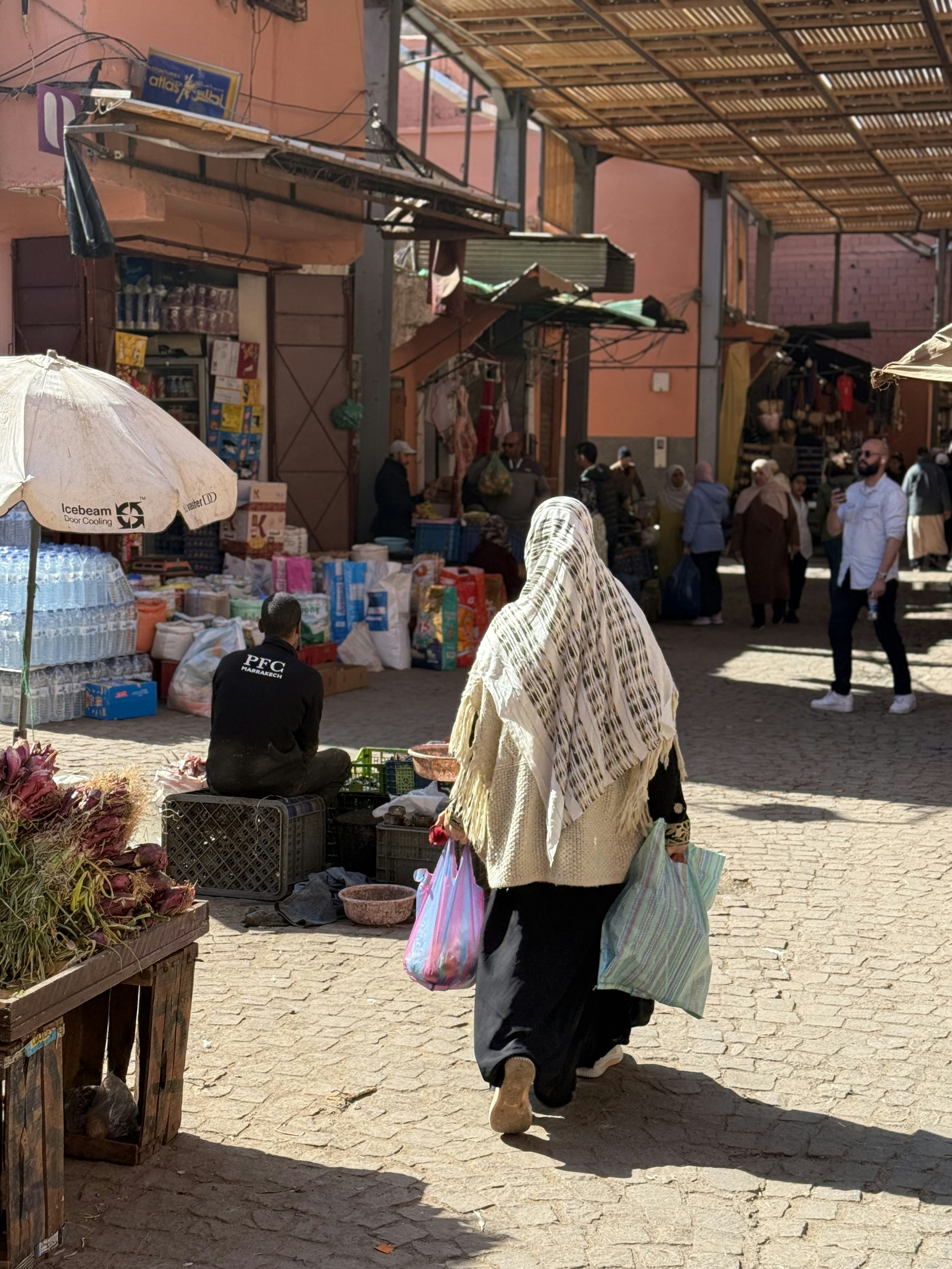 Una donna cammina in un mercato affollato.