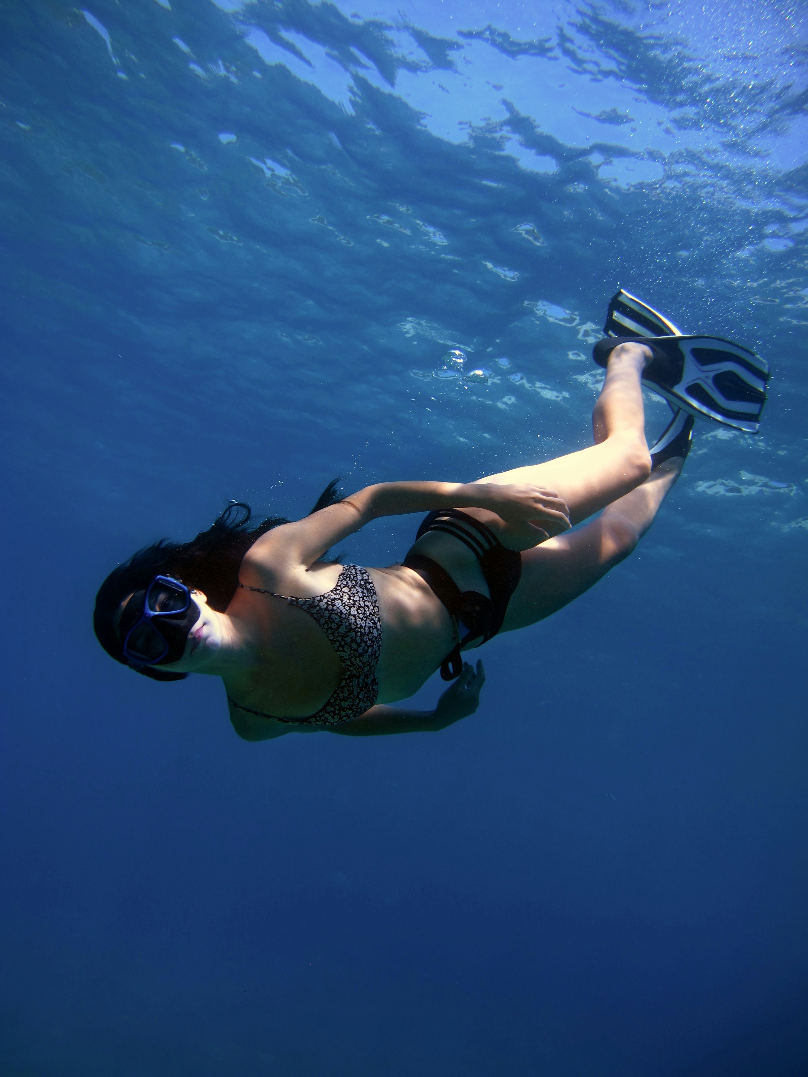 A woman snorkels in the deep, blue water.