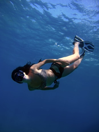 A woman snorkels in the deep, blue water.