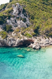 Rocky coast with turquoise water and lush greenery.