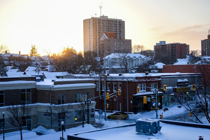 Snow-covered buildings and a skyline at sunrise.