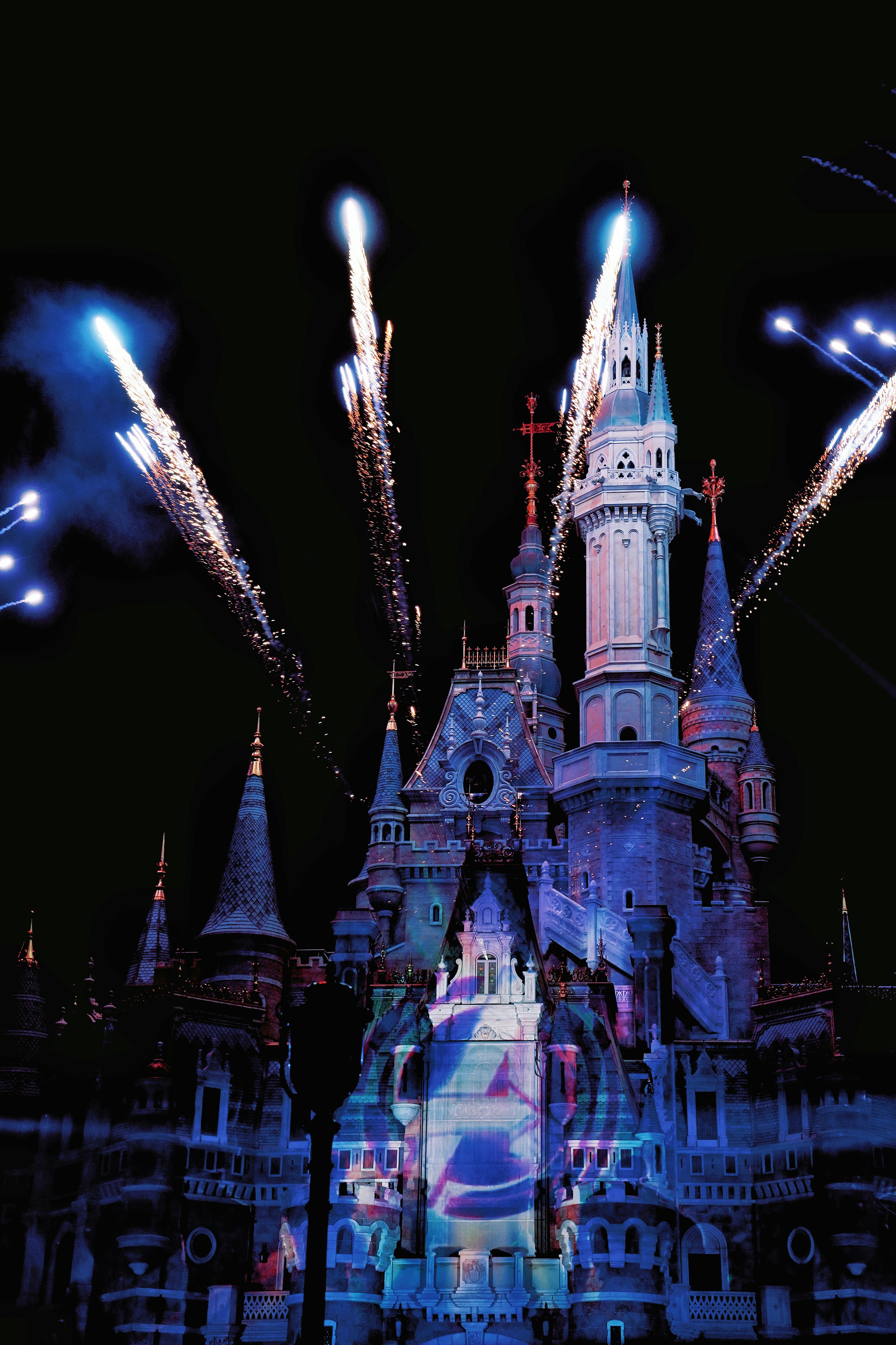 Fireworks erupt over a castle at night.