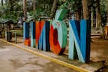Colorful "limon" sign stands in a park setting.