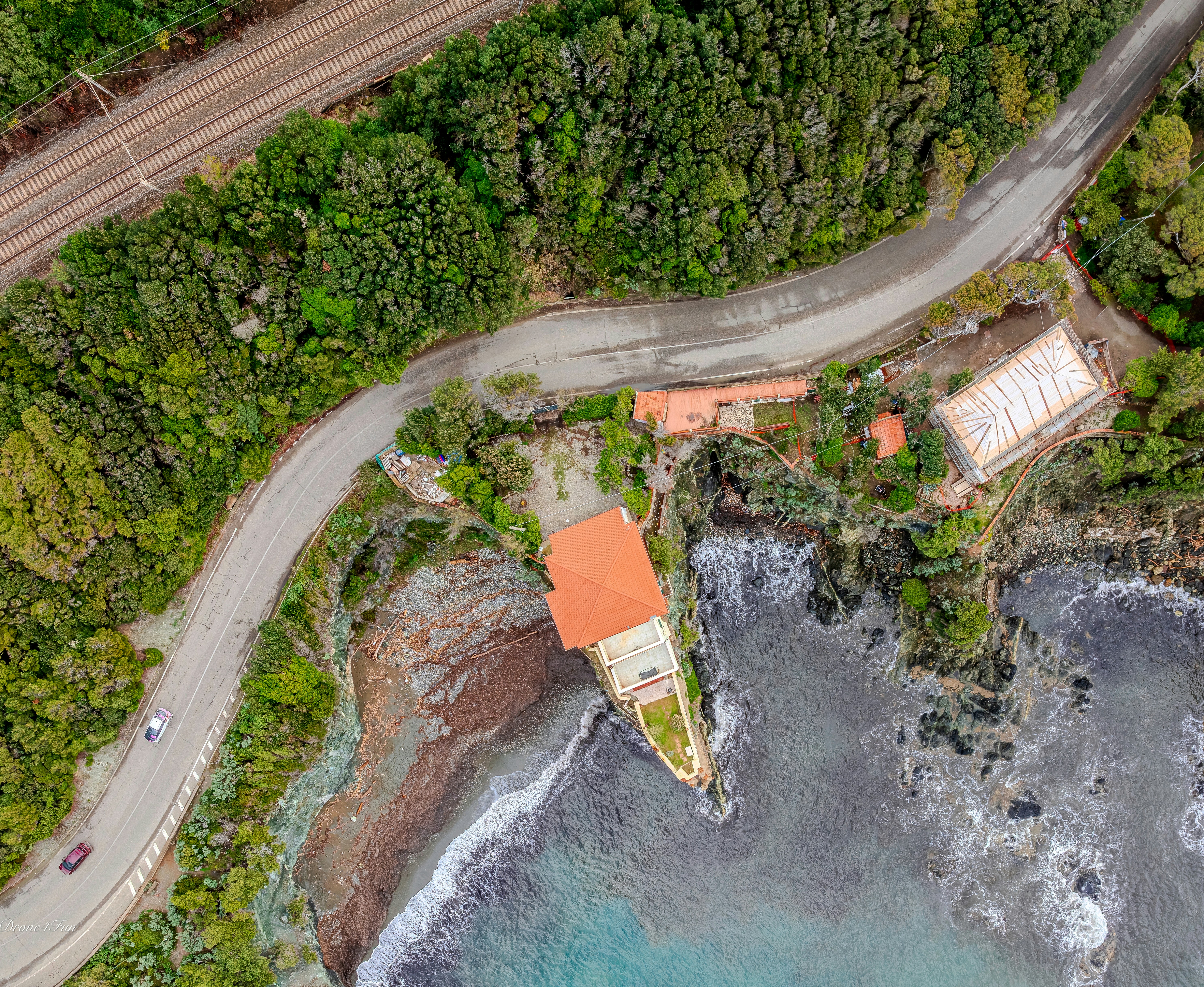 An aerial view of a coastal road and building.