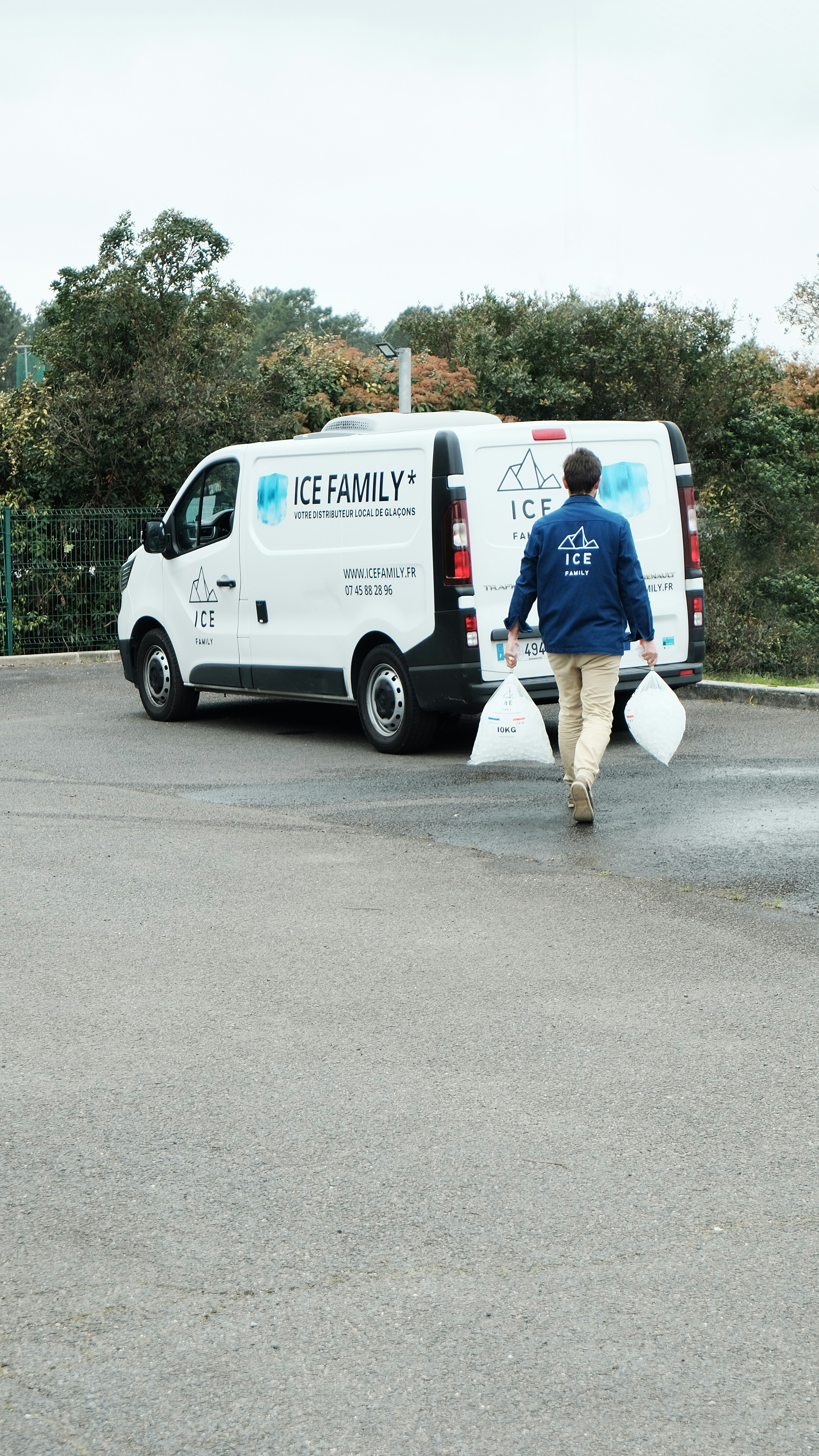 Man carries bags near the ice family van.