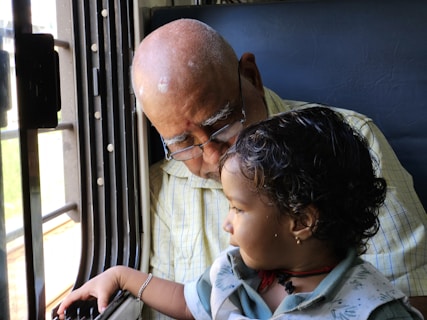 Grandfather and child look out the window.