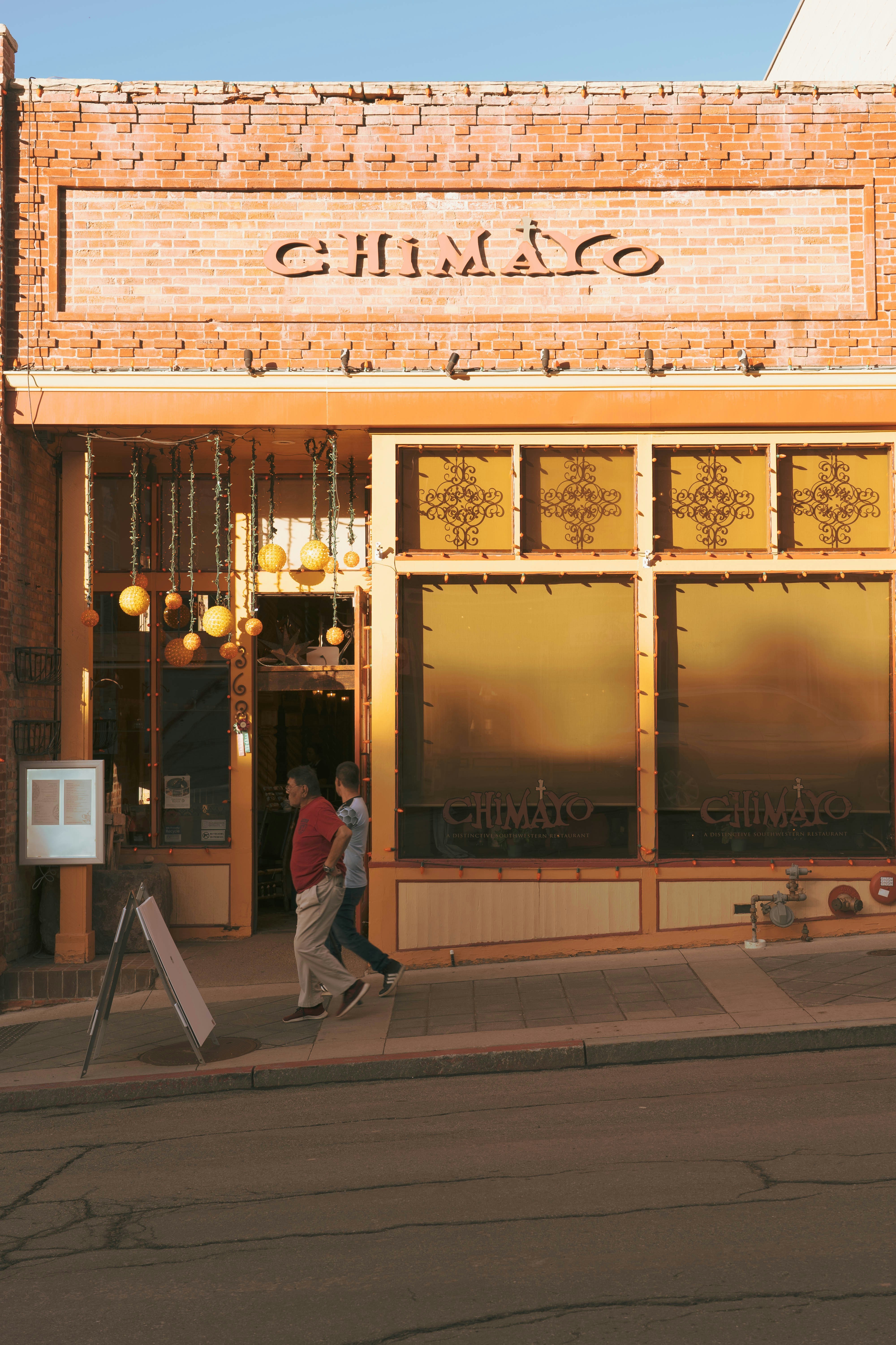 Ein Restaurant namens Chimayo mit Leuten, die gehen.