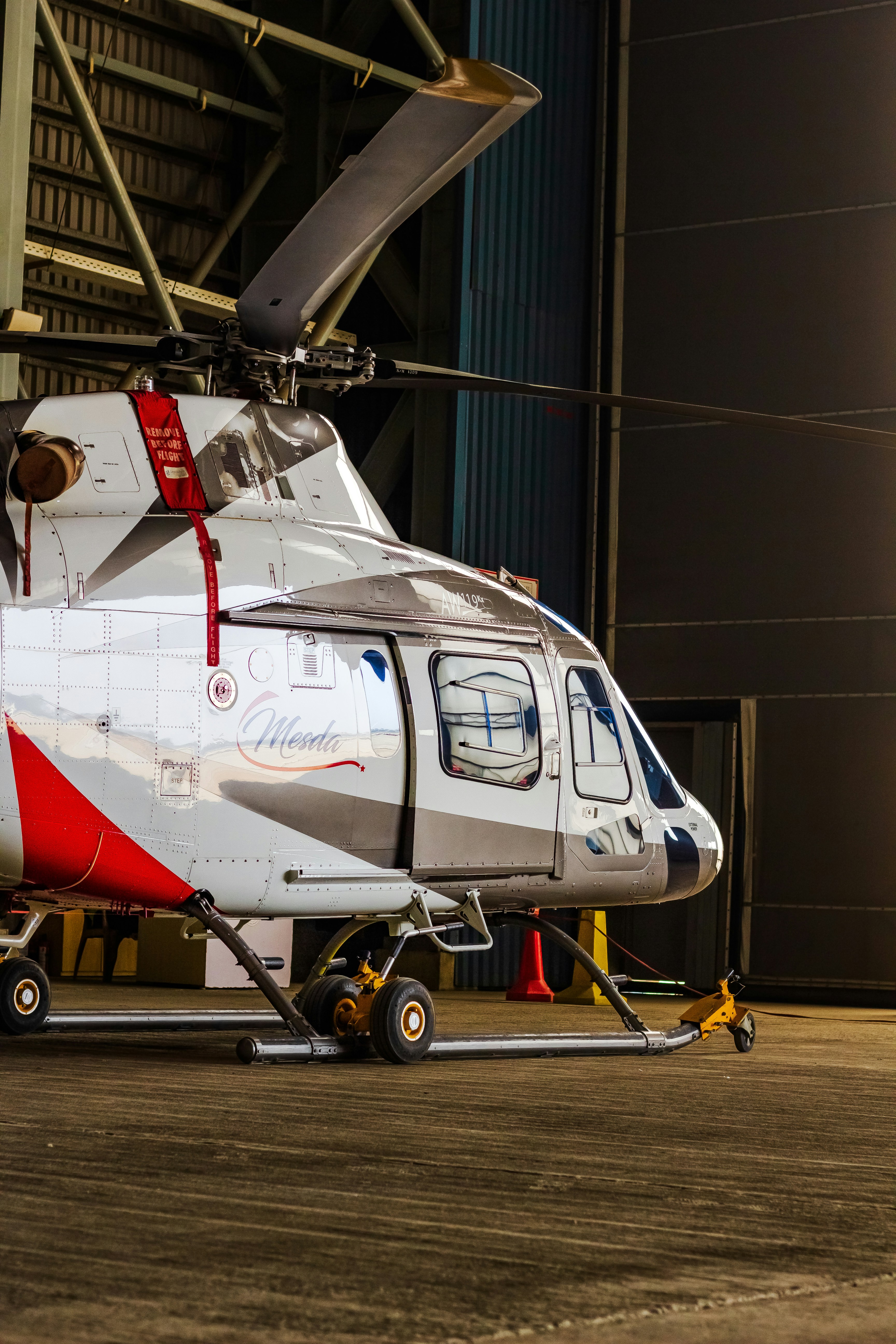 A helicopter rests inside a hangar.