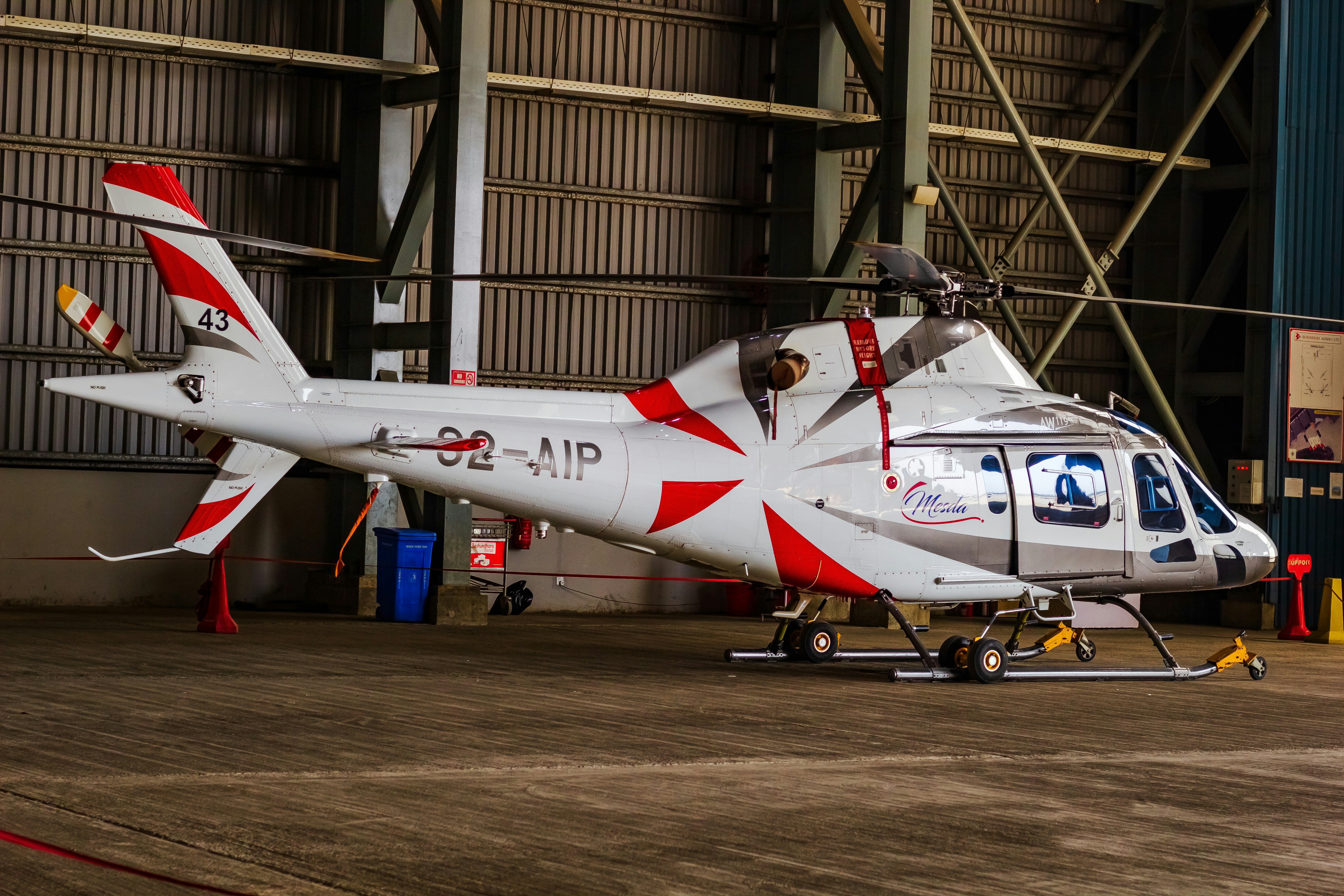 A helicopter sits inside a hangar., Bashundhara Airways AW119