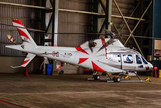 A helicopter sits inside a hangar.