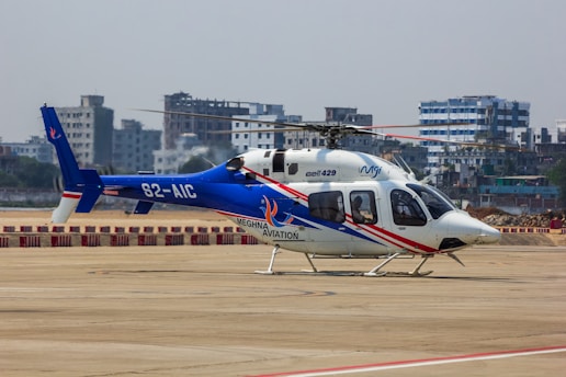 A blue and white helicopter stands ready to fly.