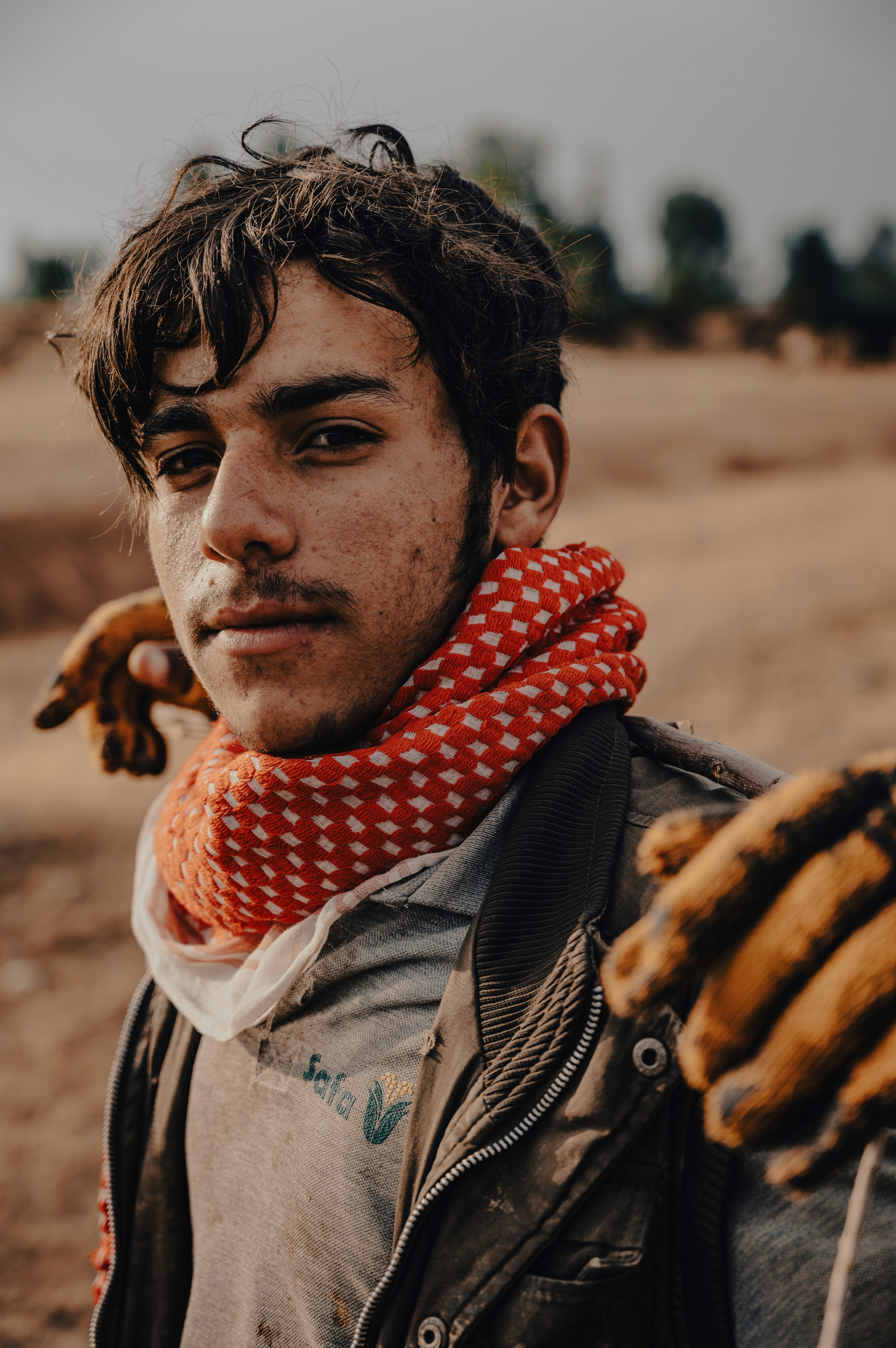 Young man poses with red scarf and gloves