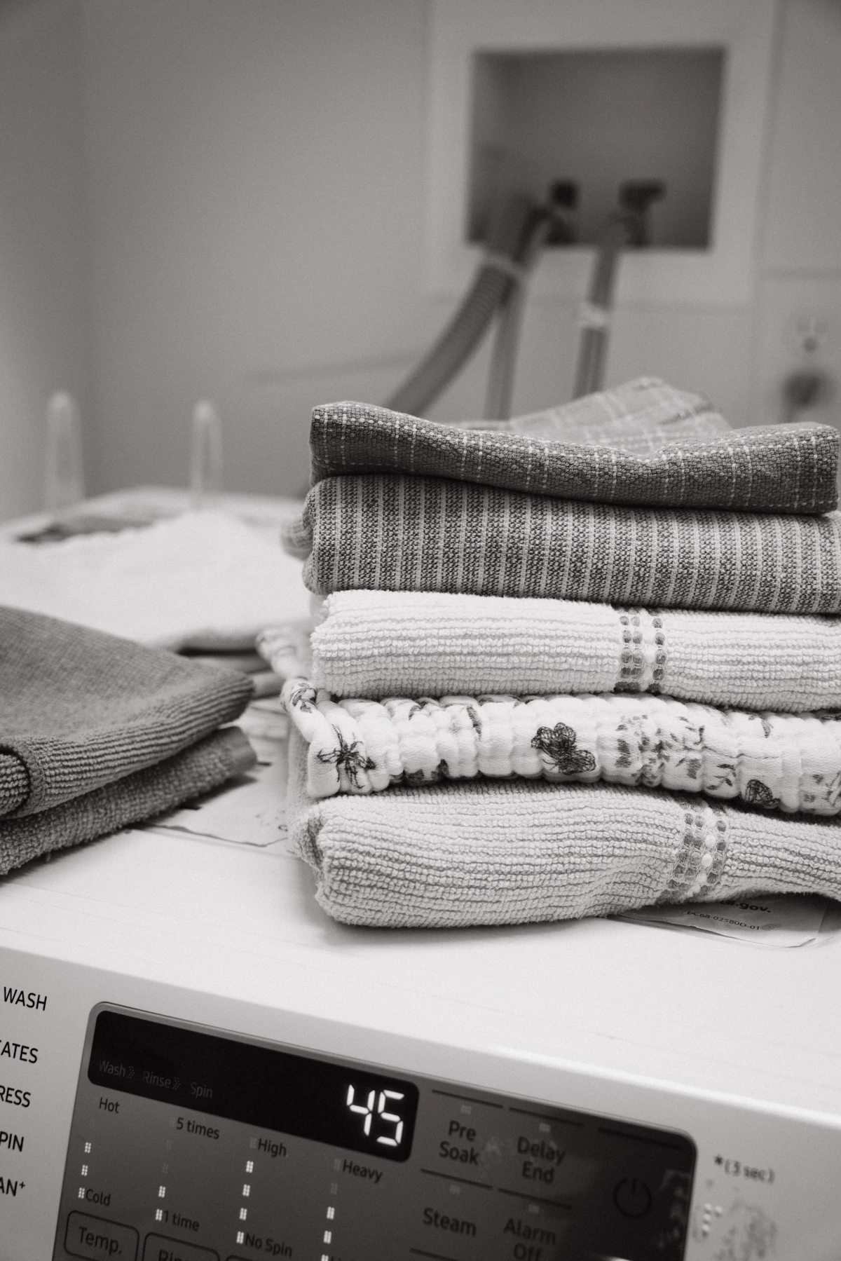 Freshly folded laundry on a modern washing machine