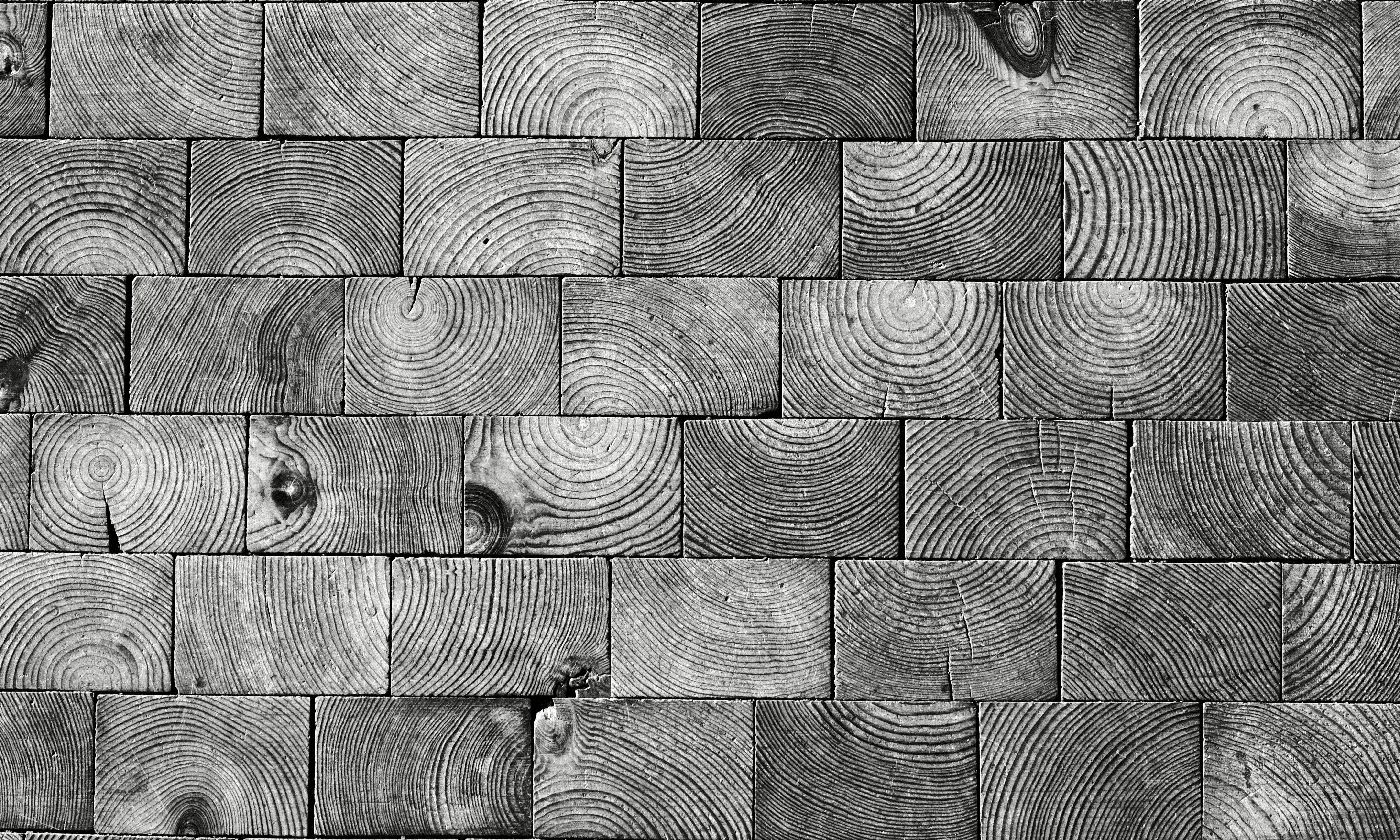 Holzklötze, die zu einer strukturierten Wand angeordnet sind.