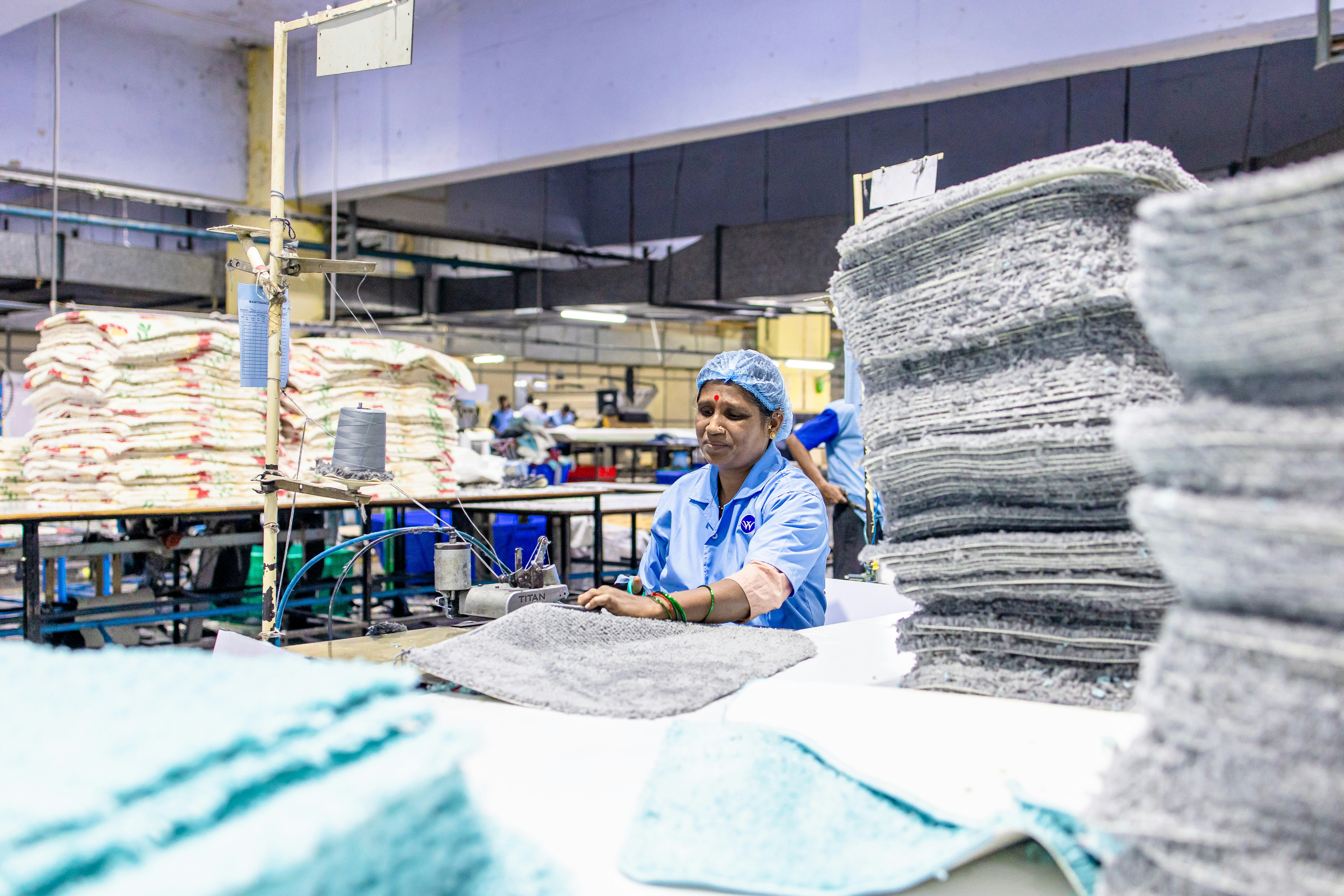 Ouvrier d’usine inspectant des serviettes dans une usine textile.