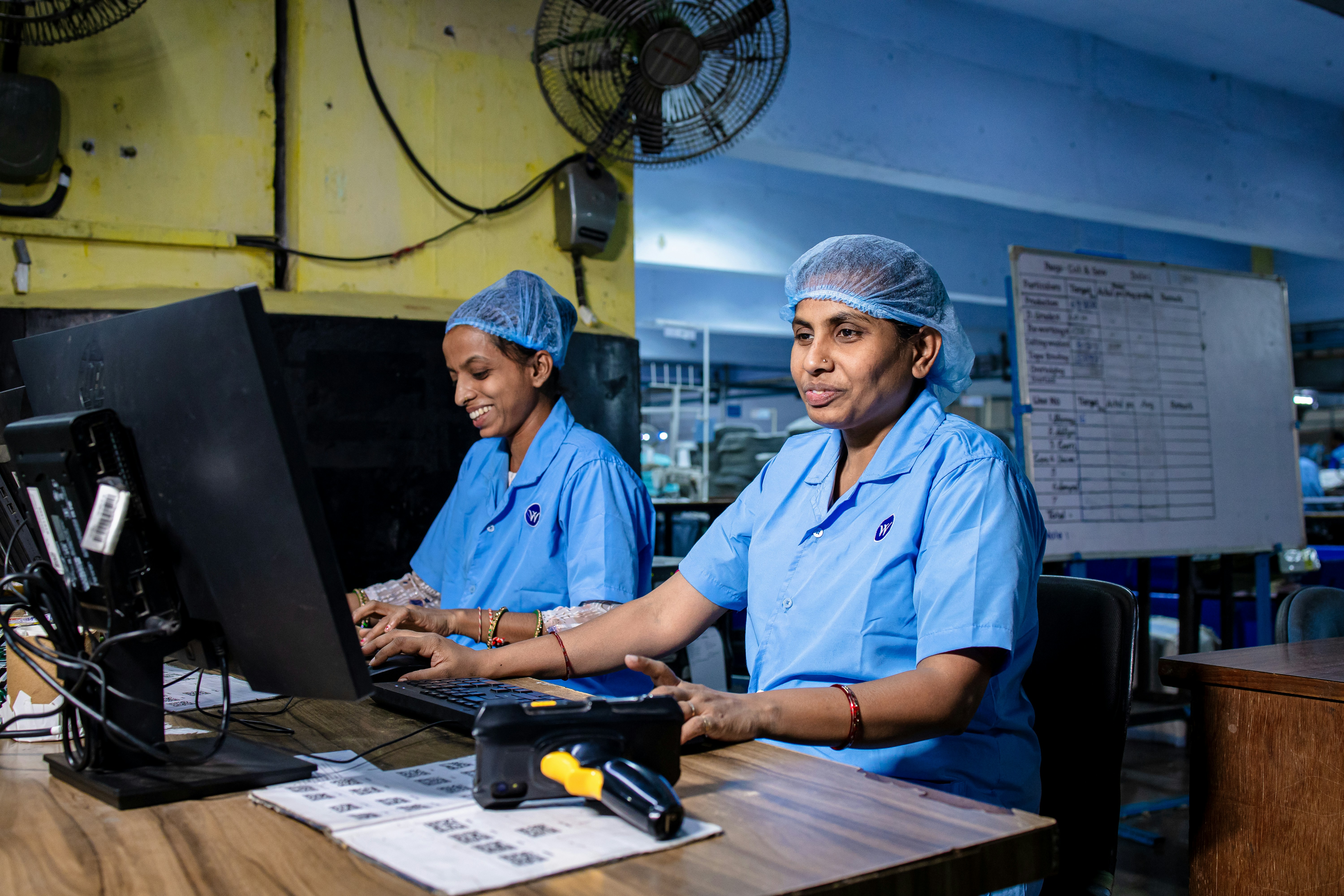 Two women work together at a computer.