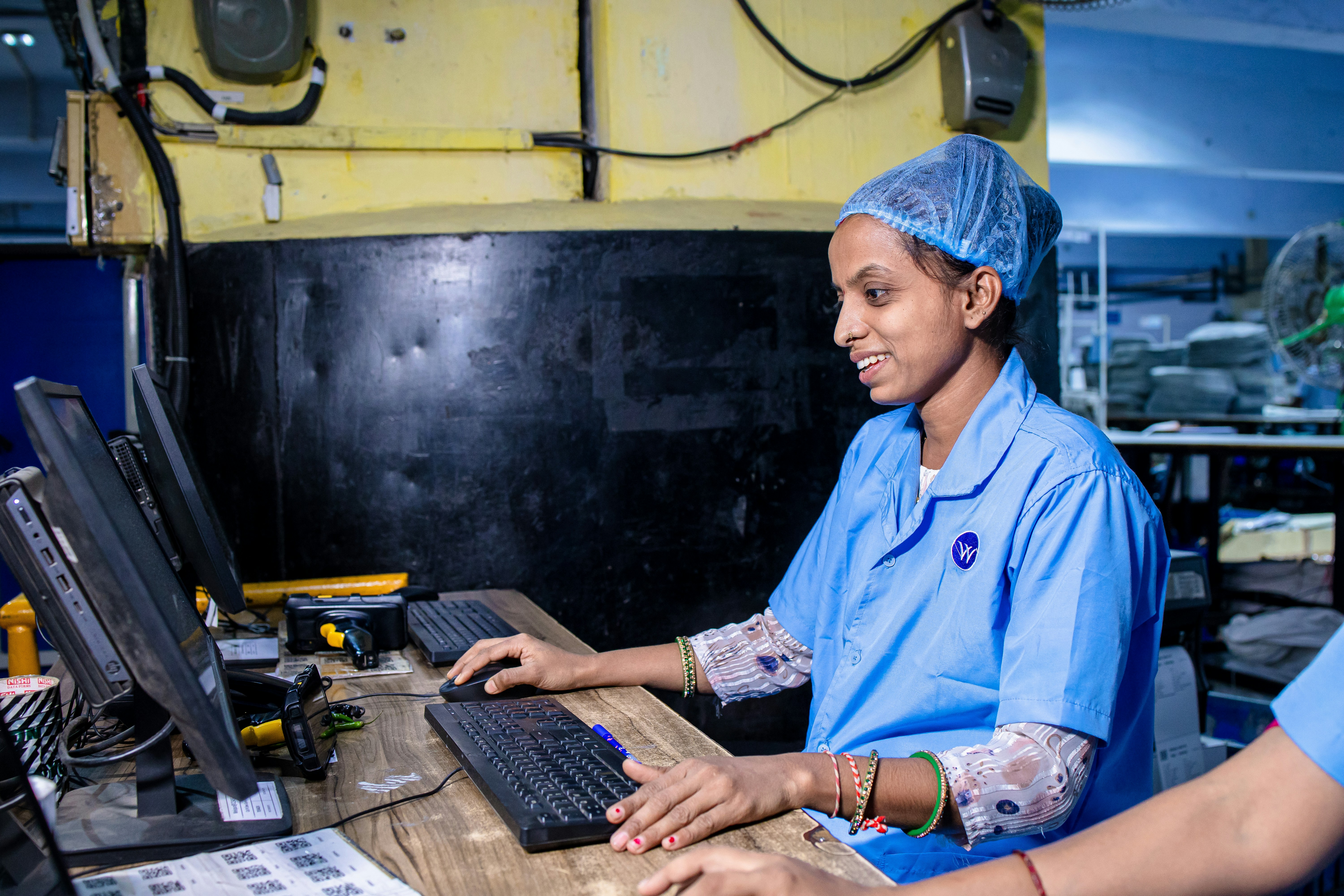 A woman works on a computer in a factory.