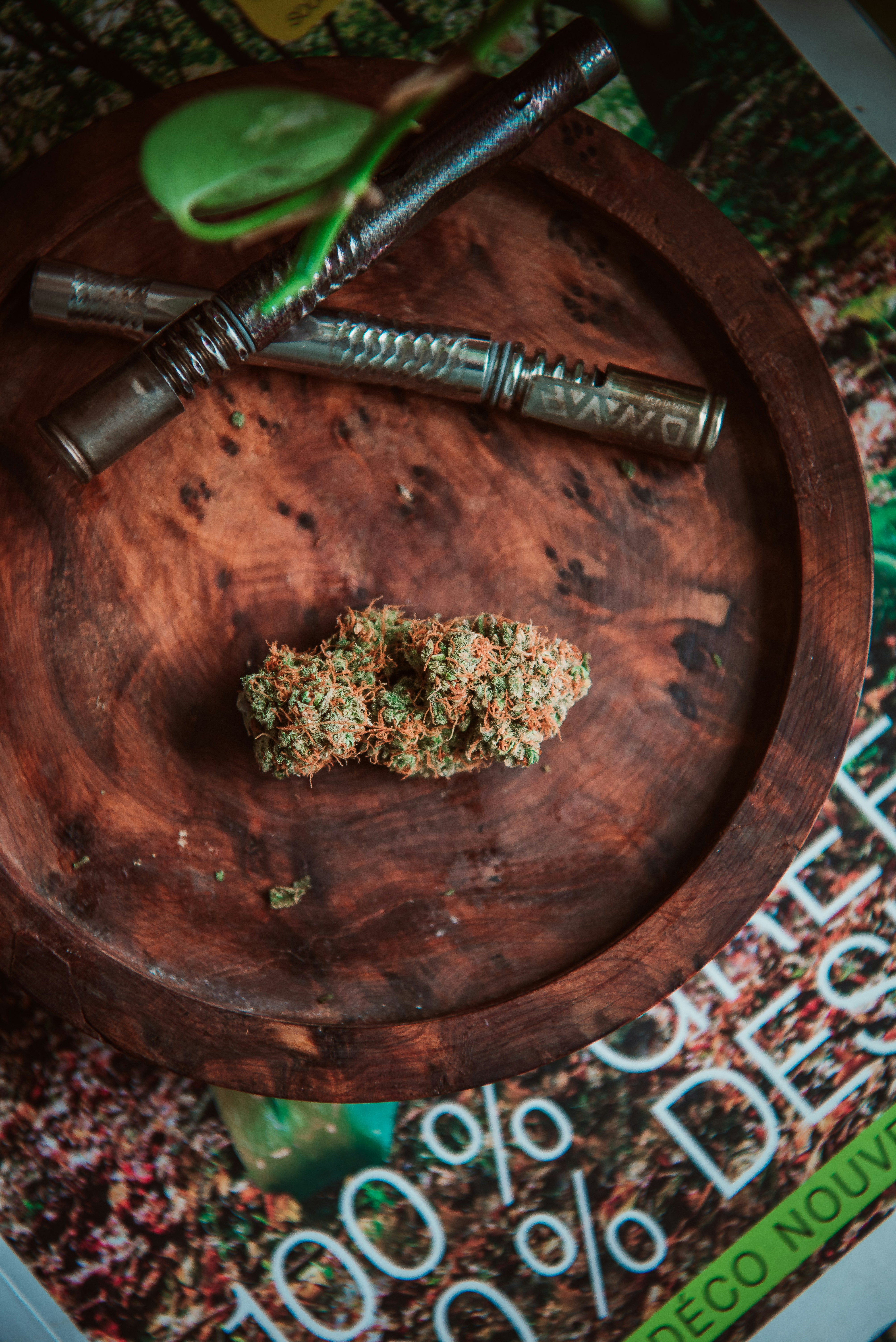 Eine Cannabisknospe und ein Vaporizer befinden sich auf einer Holzplatte.