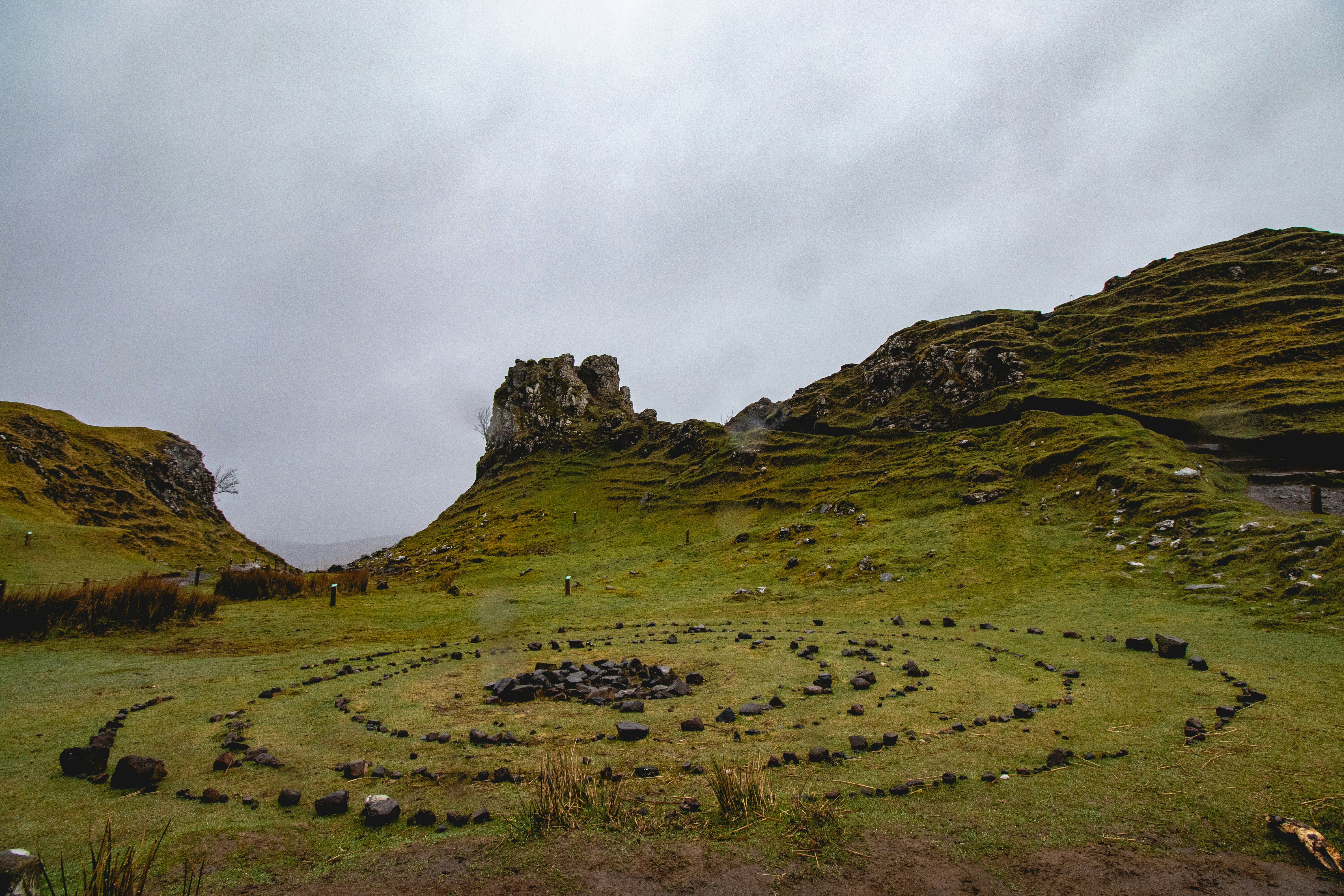 Stone spiral in a field with rocky hills