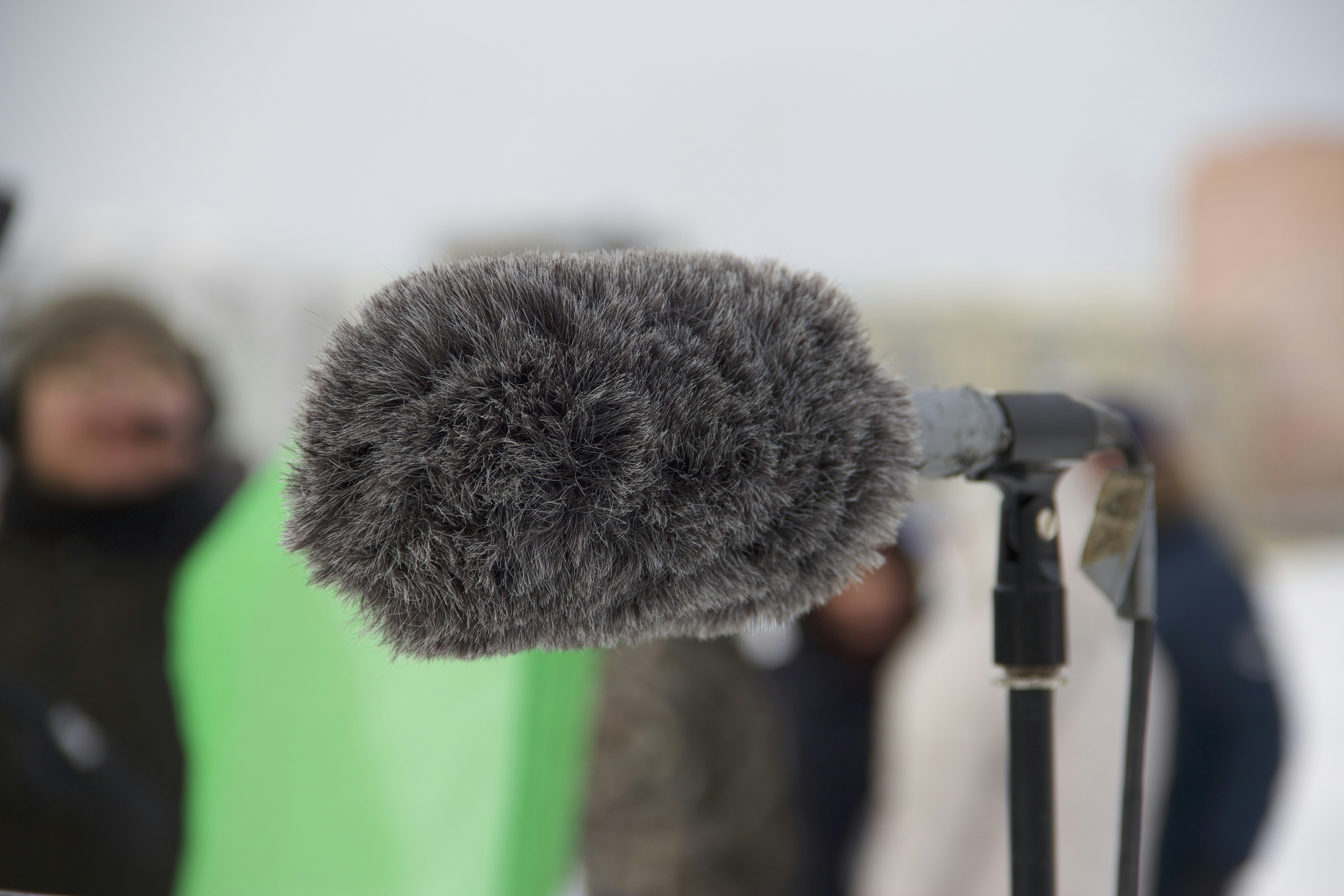 Microphone with a fuzzy windscreen, outdoors.