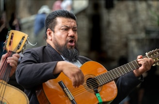 A musician sings while playing guitar.
