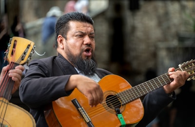 A musician sings while playing guitar.