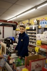 A store clerk smiles while working at the counter.