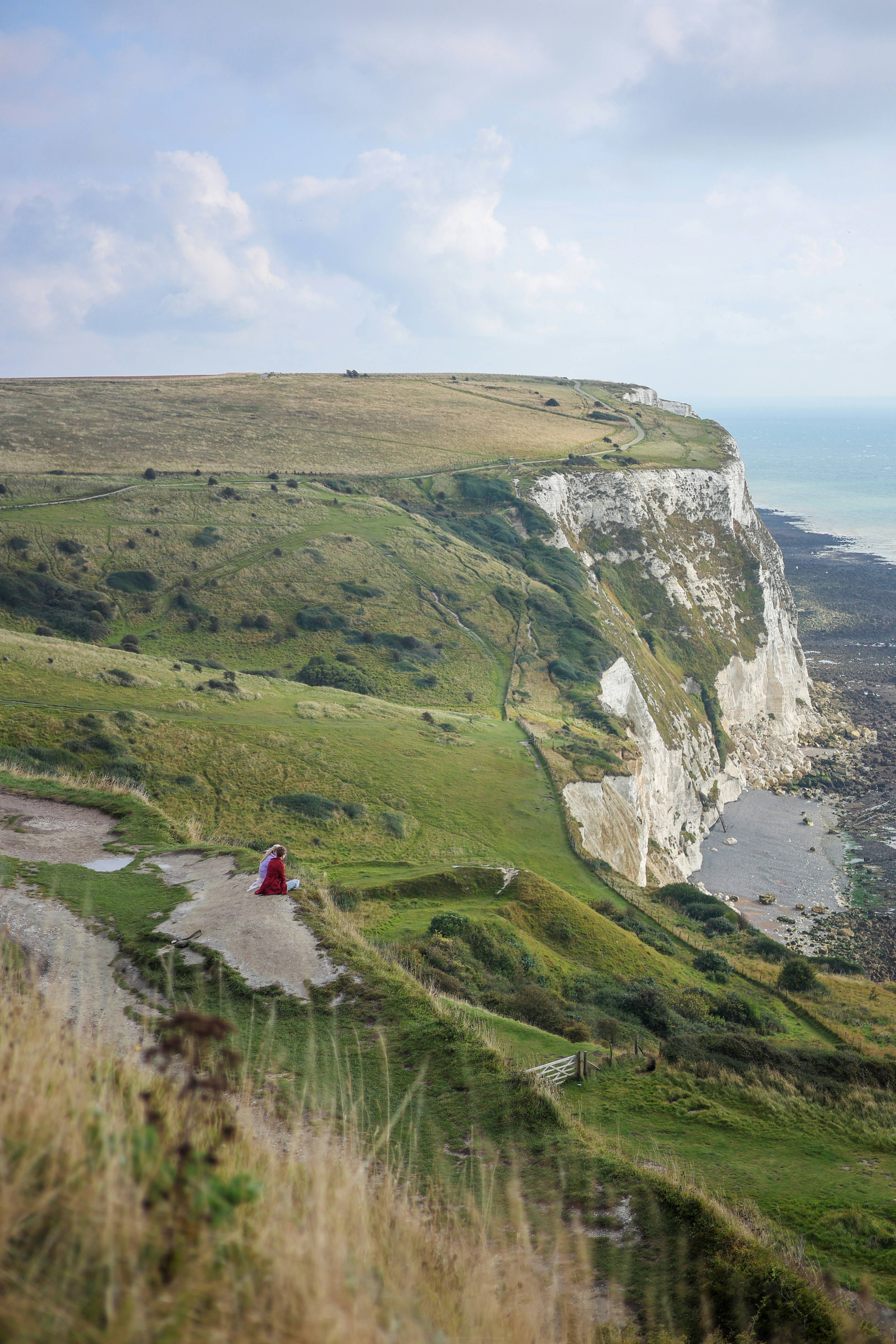 Sanfte grüne Klippen treffen auf eine weiße Küste.