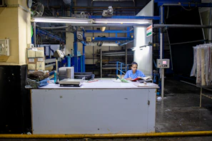 Woman works at a factory control desk.