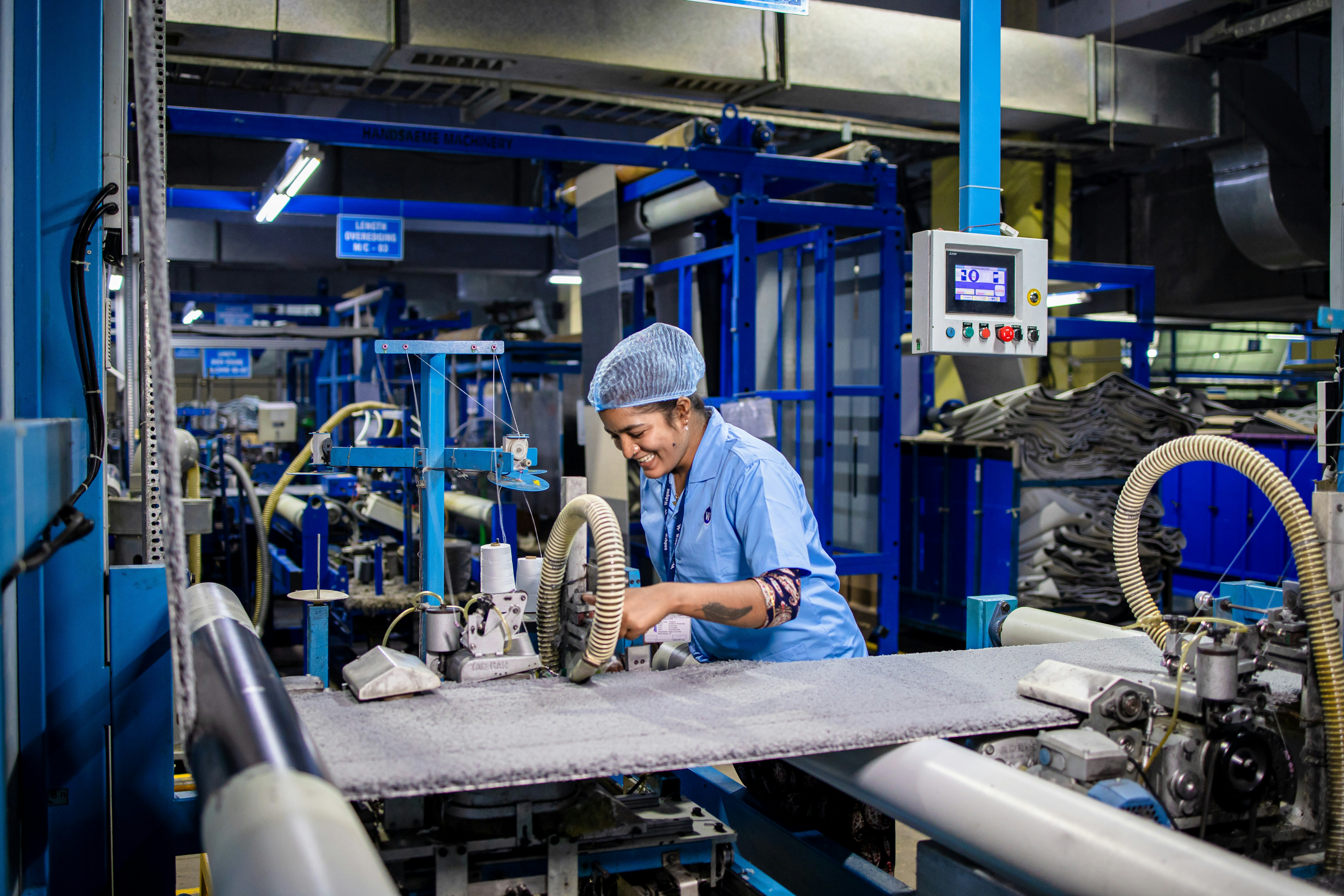 Worker operates machinery in a textile factory.