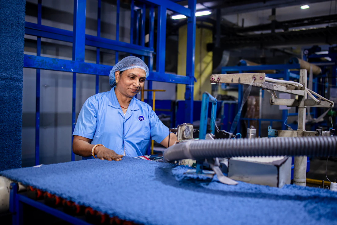 Worker operating carpet finishing equipment
