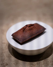A delicious chocolate financier on a white plate.