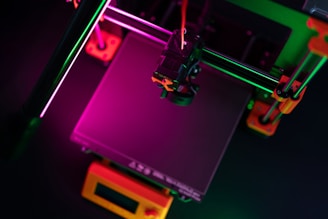 A 3D printer illuminated with colorful lights.