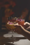 People toast with fancy, decorated cocktails.