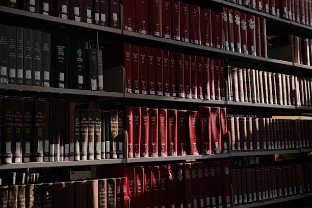 Books fill shelves in a well-lit library.